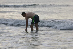 man stands in the surf at the Jersey shore