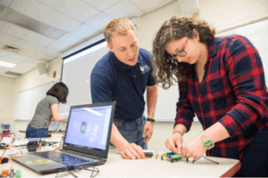 Tanner Huffman works with a student in his iSTEM class