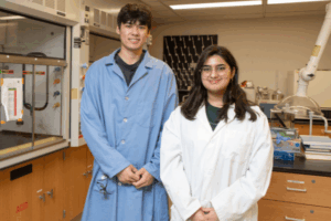 two students in a chemistry lab wearing lab coats