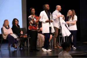 student receives white coat in annual nursing ceremony